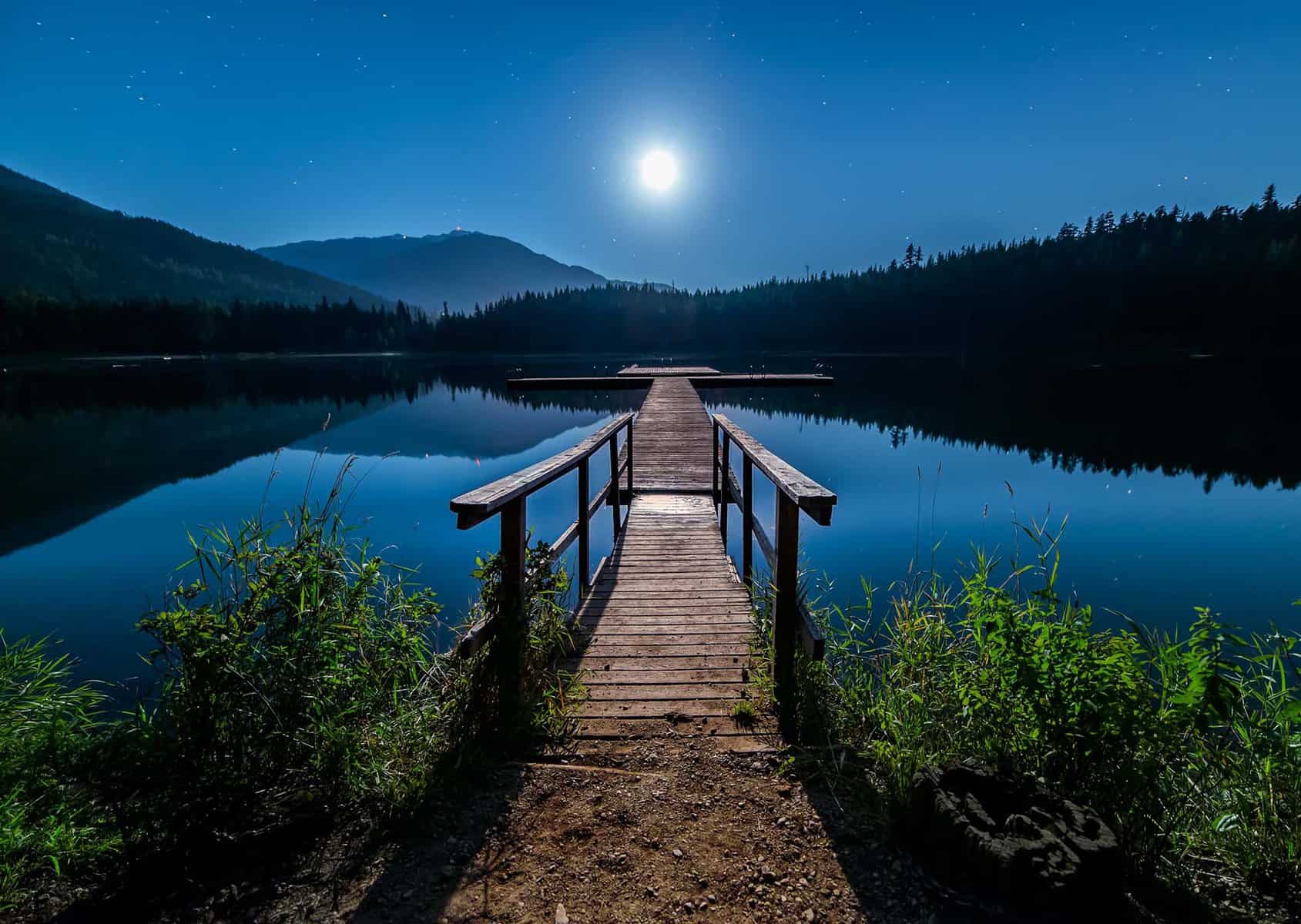 Image of a lake in Canada showing a pier pointing to the moon